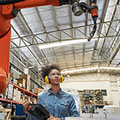 image of worker looking at robotic machinery